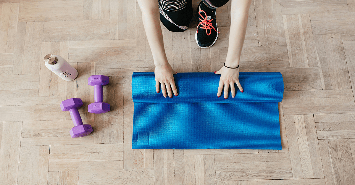 Ženska na tleh zvija modro fitnes blazino