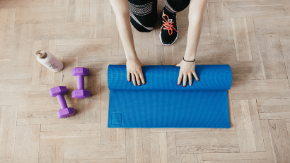 Ženska na tleh zvija modro fitnes blazino