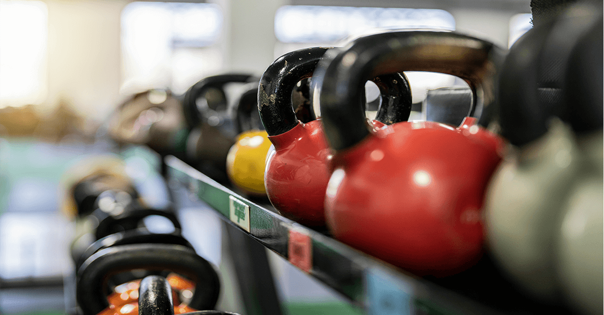 slika pisanih dumbell ročk na stojalu v vrsti