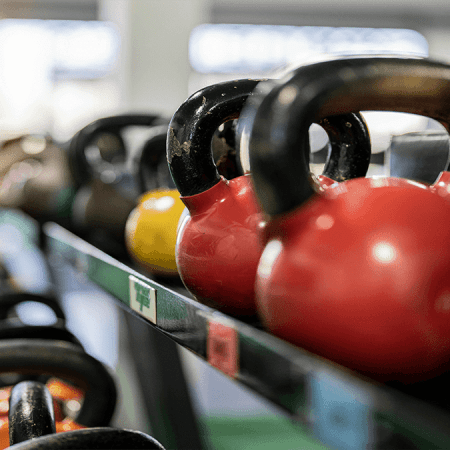 slika pisanih dumbell ročk na stojalu v vrsti