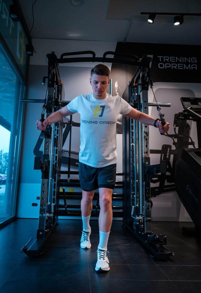 Mlad moški uporablja večnamensko fitnes napravo Shua za trening